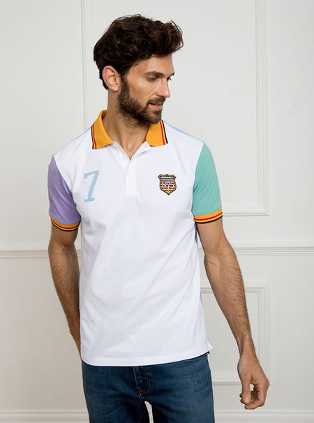 Man wearing multicoloured polo shirt with newmarket 875 crest on the front and number 7 on the back, made of 100% cotton.
